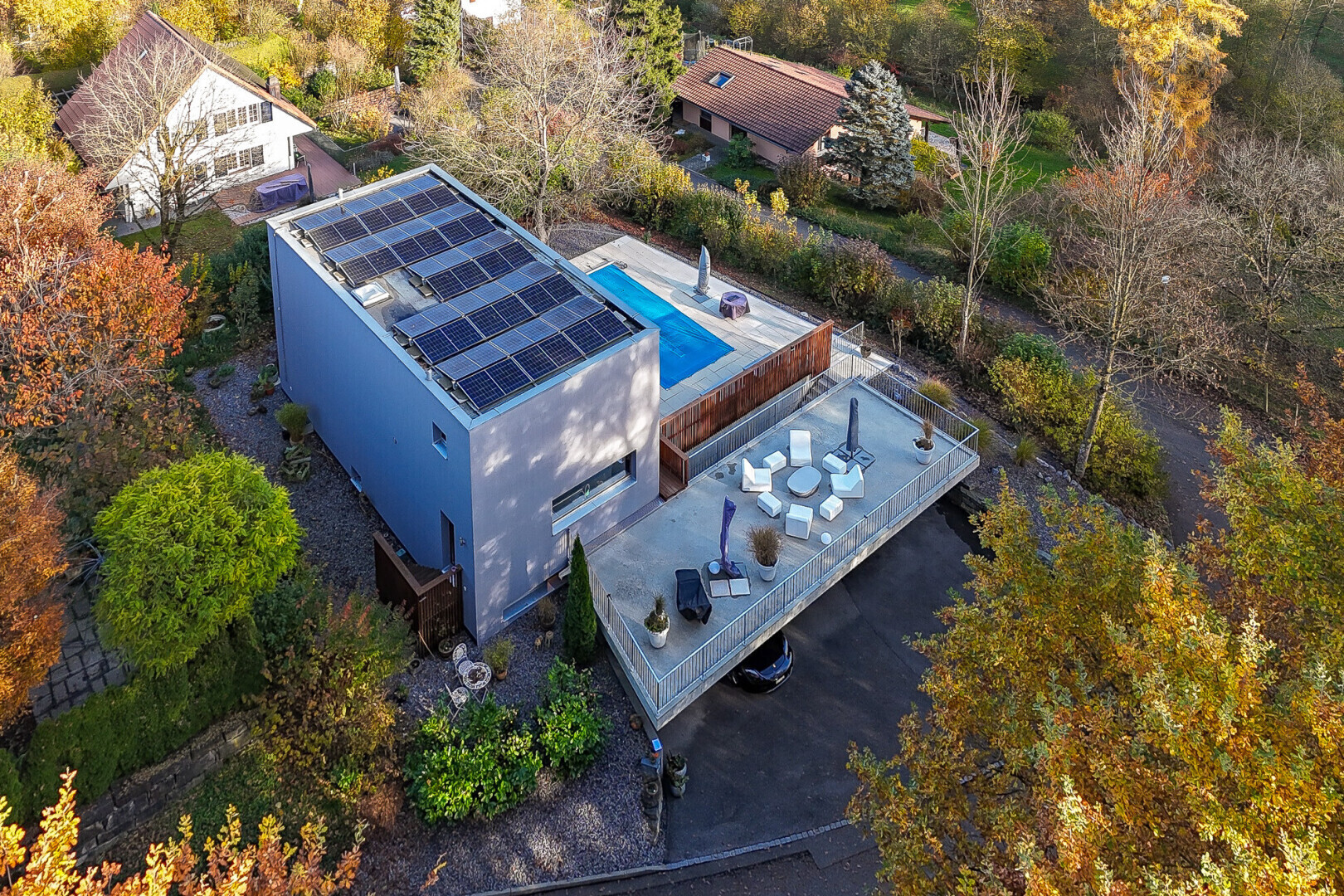 façade avec panneaux solaires, terrasse, et allée