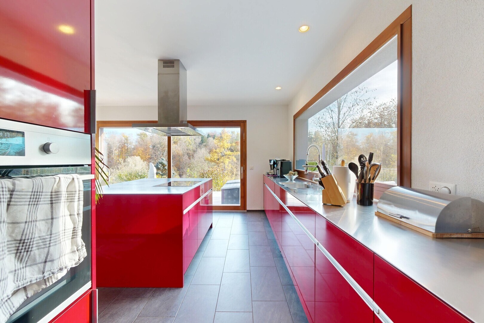cuisine avec armoires rouges, red cabinets, four, armoires à panneau plat, et flat panel cabinets