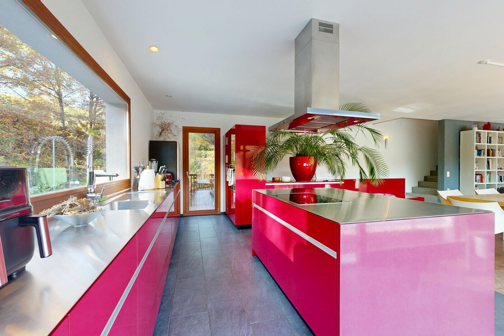cuisine avec red cabinets, armoires rouges, stainless steel countertops, plans de travail en acier inoxydable, et flat panel cabinets
