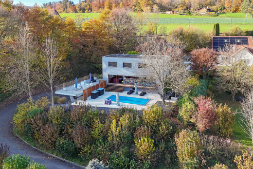 façade avec terrasse, piscine, property visible, et espace de vie extérieur