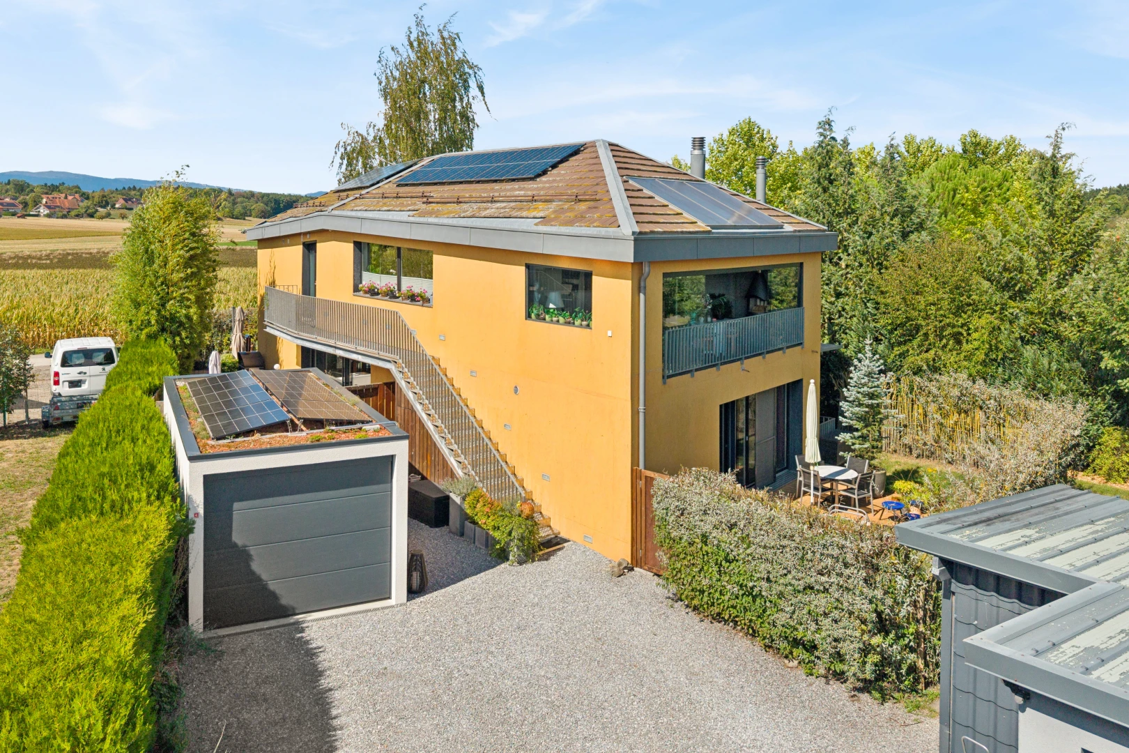 façade avec panneaux solaires, drone view, garage, allée, et bardage en stuc