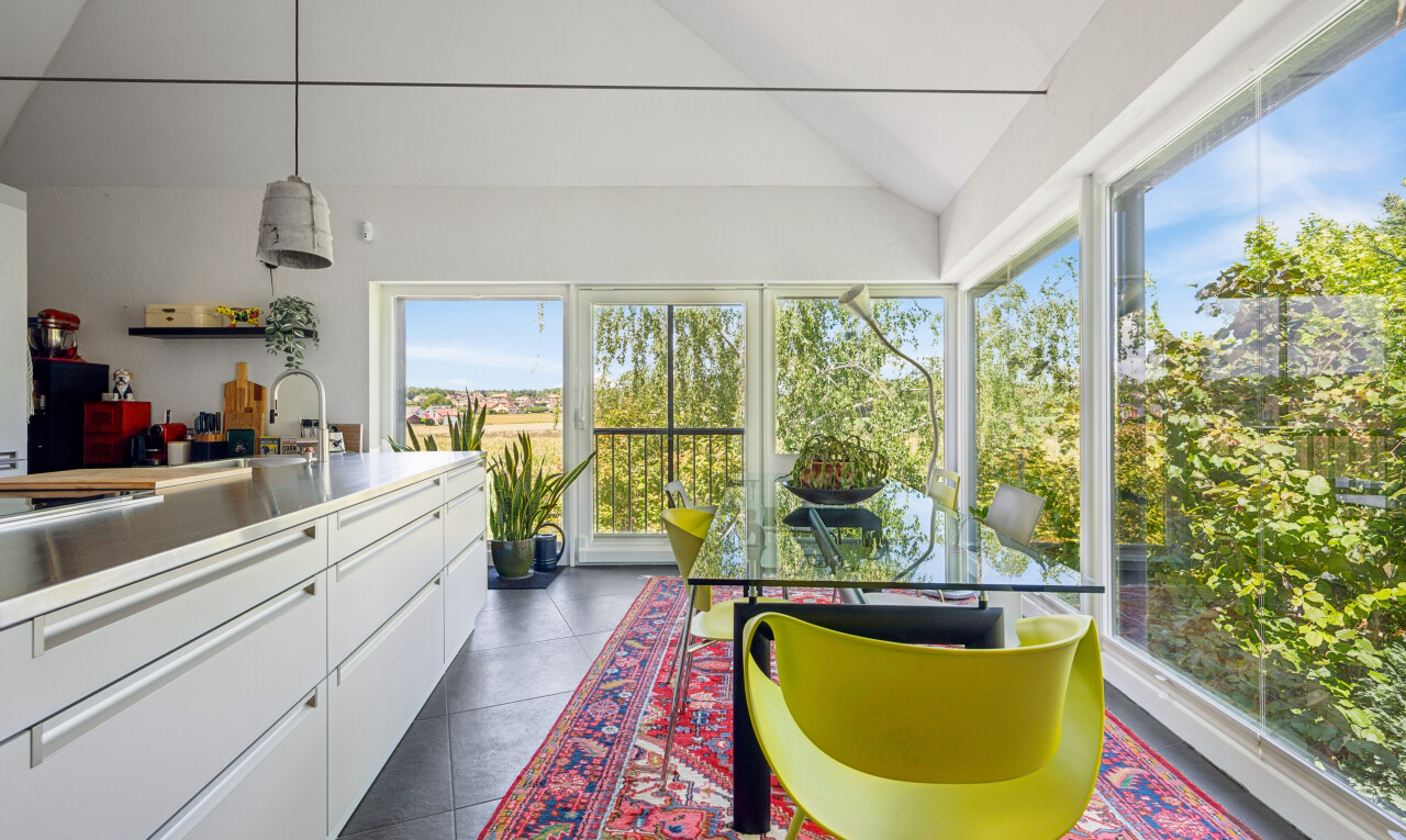 kitchen with decorative light fixtures, white cabinets, vaulted ceiling, and stainless steel counters