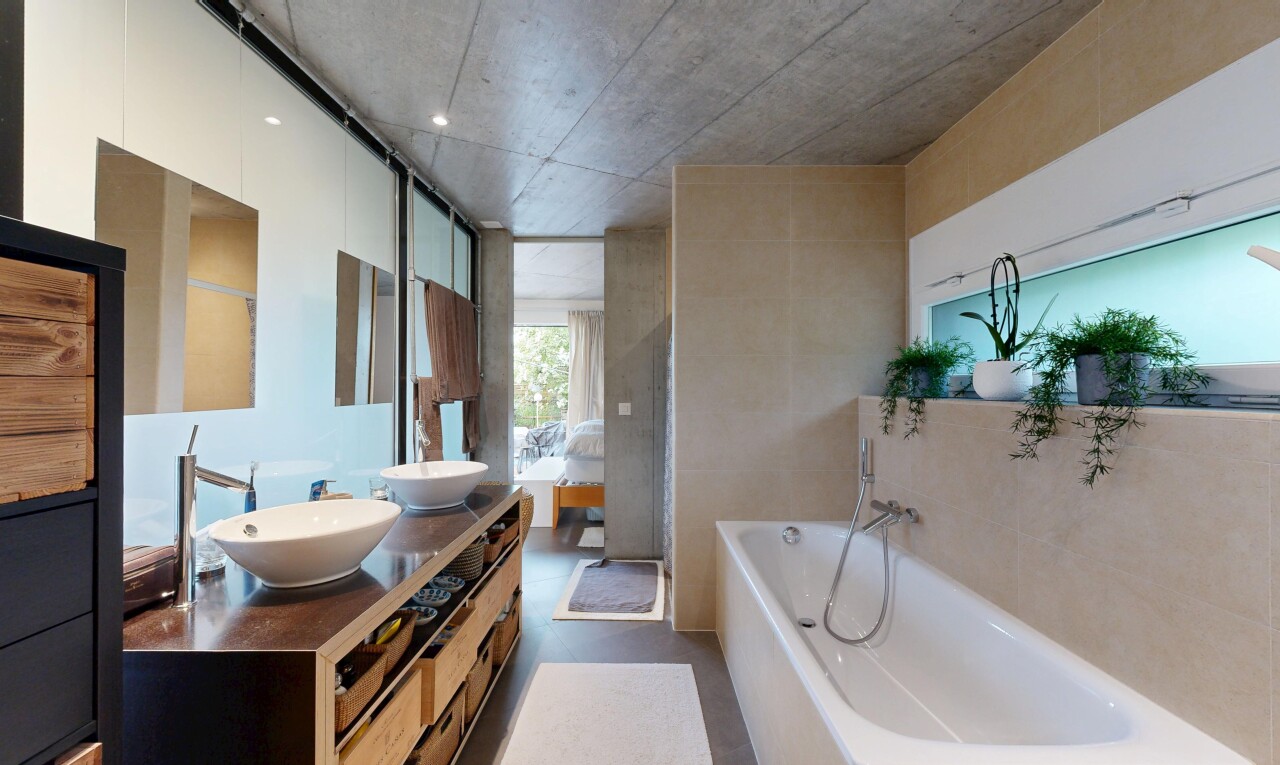 bathroom with double vanity and a bath