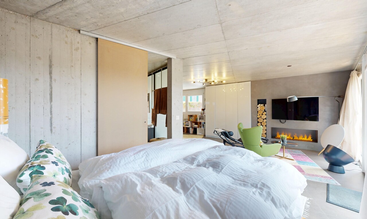 room / bedroom featuring a warm lit fireplace