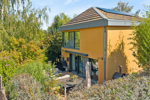 façade avec terrasse, property visible, panneaux solaires, bardage en stuc, et day time
