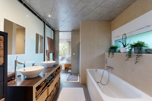 bathroom with double vanity and a bath