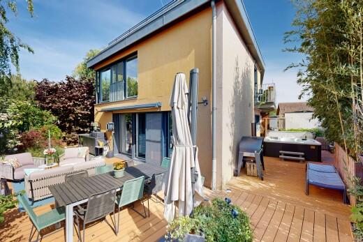view of wooden deck featuring outdoor dining area, a balcony, and a hot tub