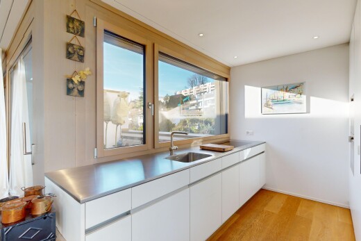 küche mit arbeitsplatten, parkettboden, weiße schränke, natürliches licht, und waschbecken