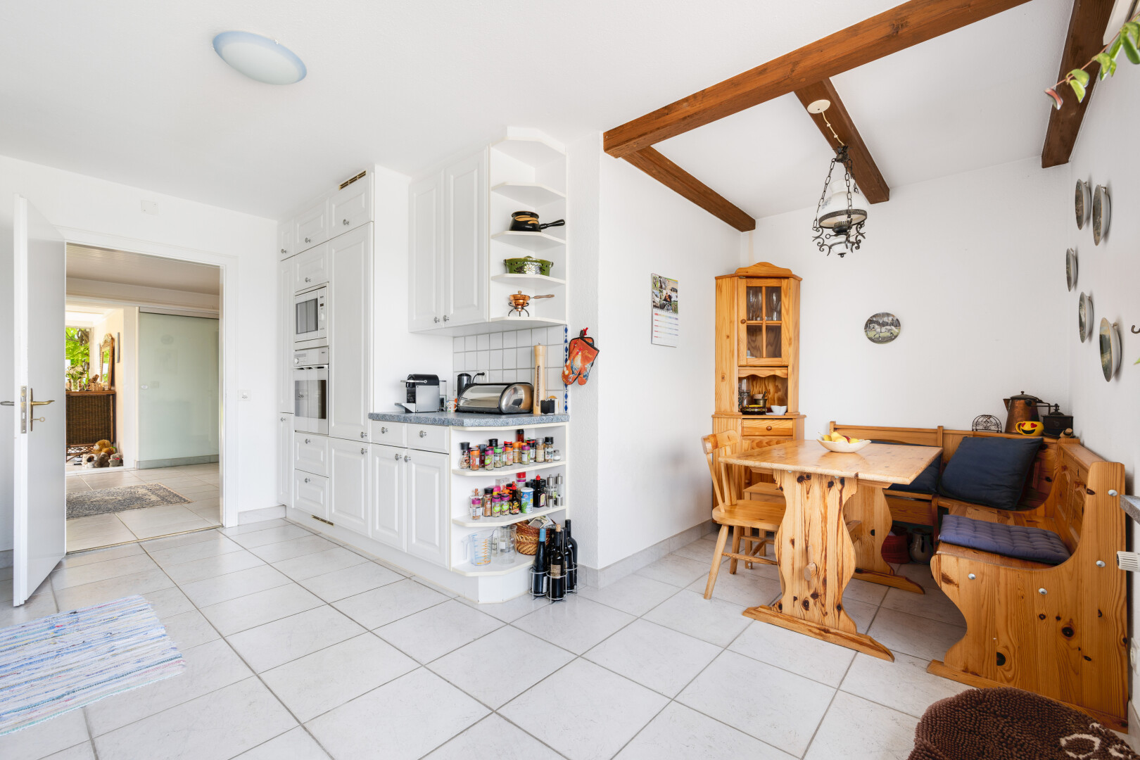 esszimmer mit light floor, balkendecke, beamed ceiling, küchenrückwand beim Herd, und gipskartonwand