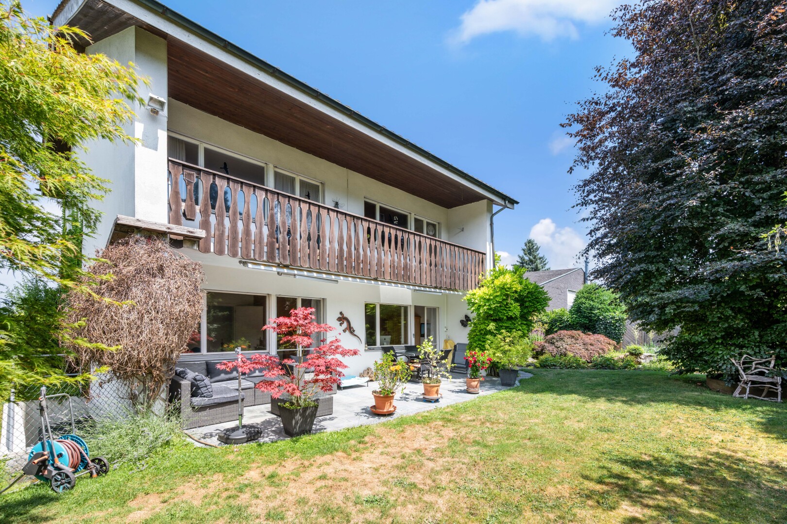 außenansicht mit balkon, rasen, terrasse, und day time
