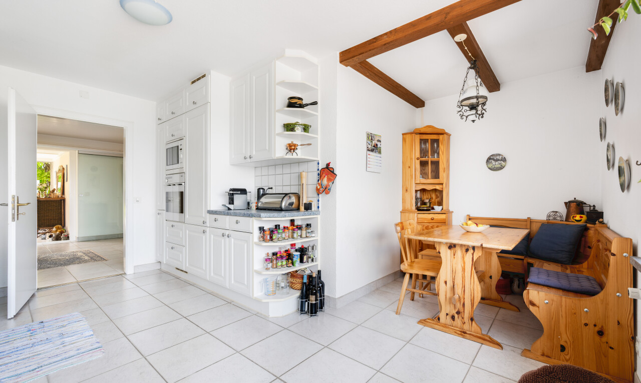 salle à manger avec light floor, plafond à poutres, beamed ceiling, backsplash, et cloison sèche