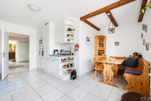 esszimmer mit light floor, balkendecke, beamed ceiling, küchenrückwand beim Herd, und gipskartonwand