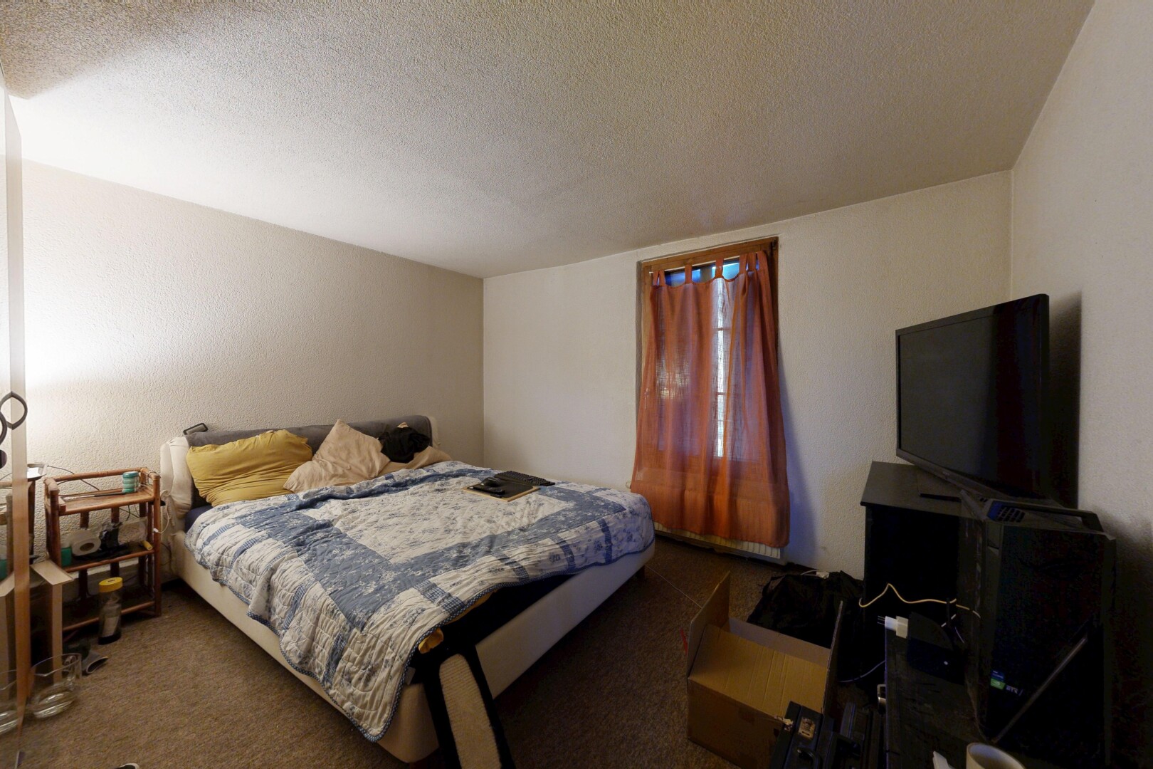 chambre avec plafond texturé, textured ceiling, télévision, moquette, et carpet