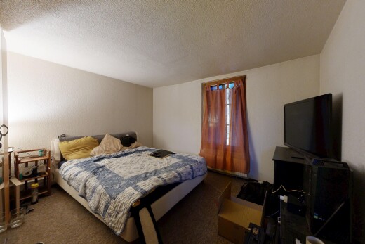 chambre avec plafond texturé, textured ceiling, télévision, moquette, et carpet