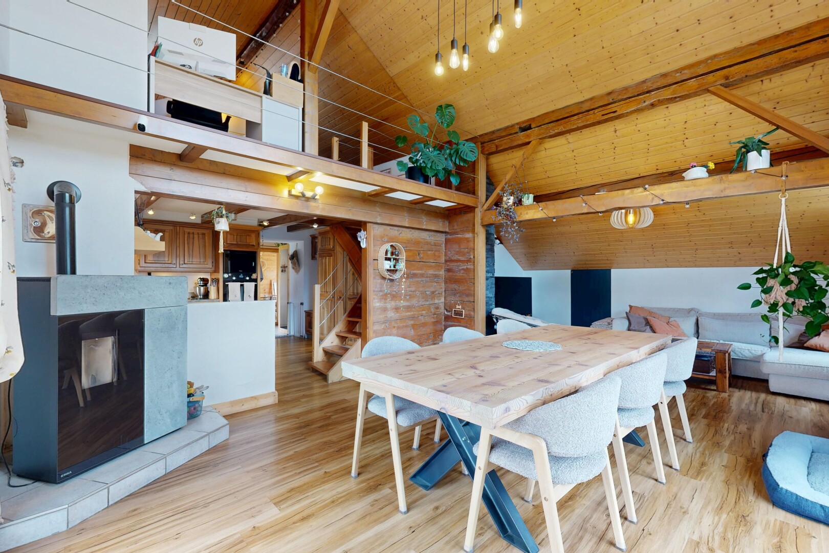 dining room with light wood-style flooring, a wood stove, a high wood beamed ceiling, and wood walls