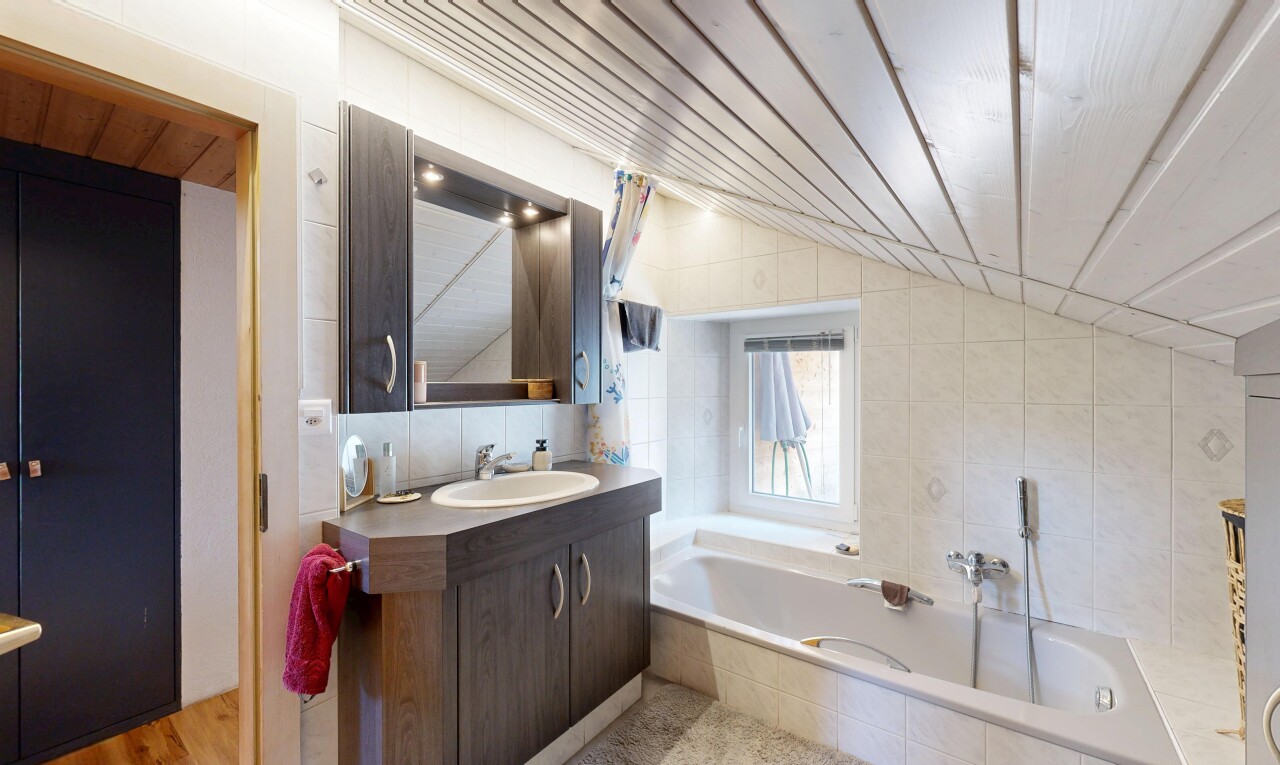 bathroom featuring tile walls, a bath, vanity, and lofted ceiling
