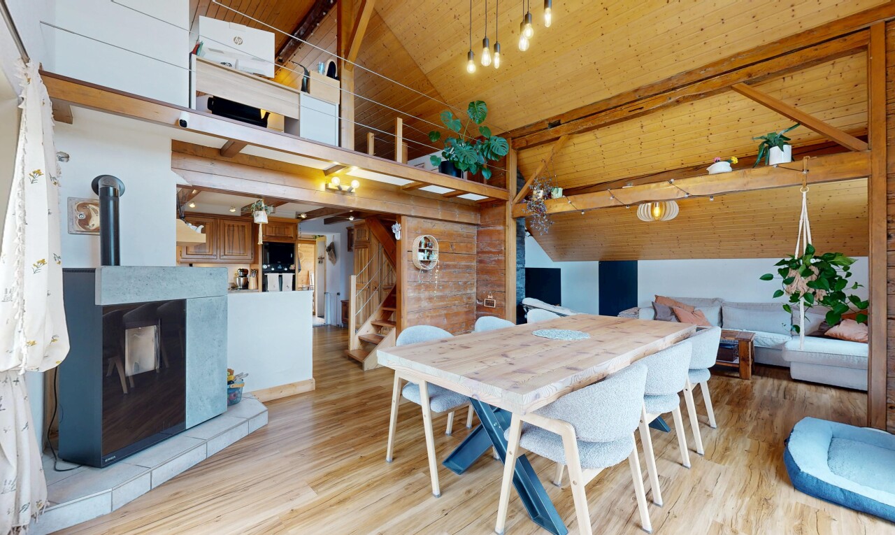 dining room with light wood-style flooring, a wood stove, a high wood beamed ceiling, and wood walls