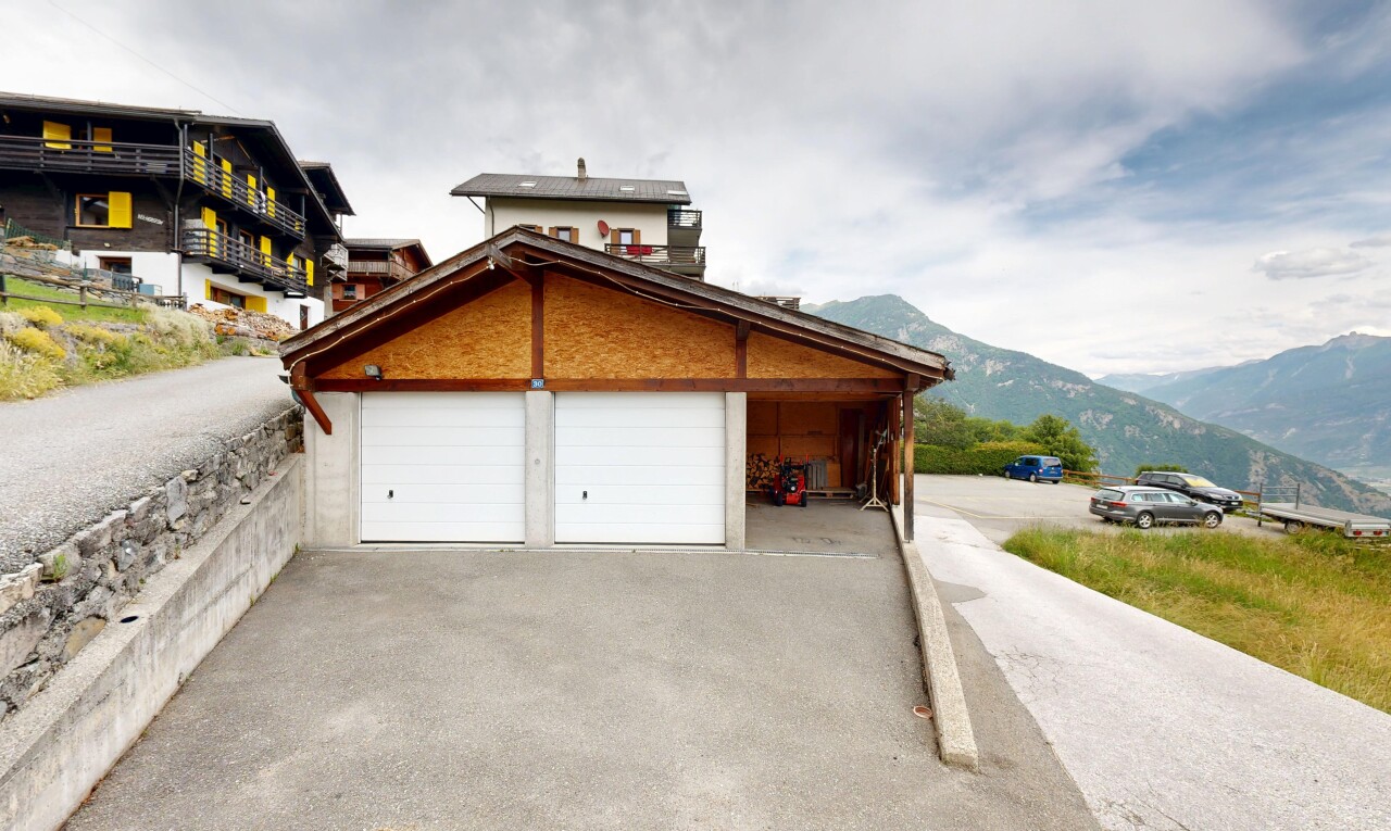 view of home featuring driveway, a mountain view, and a garage
