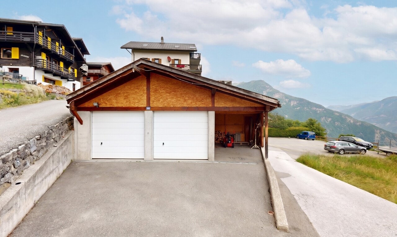 view of home featuring driveway, a mountain view, and a garage