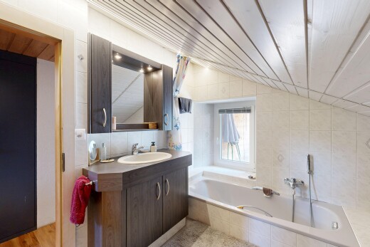 bathroom featuring tile walls, a bath, vanity, and lofted ceiling