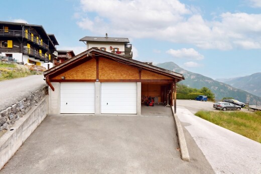 view of home featuring driveway, a mountain view, and a garage