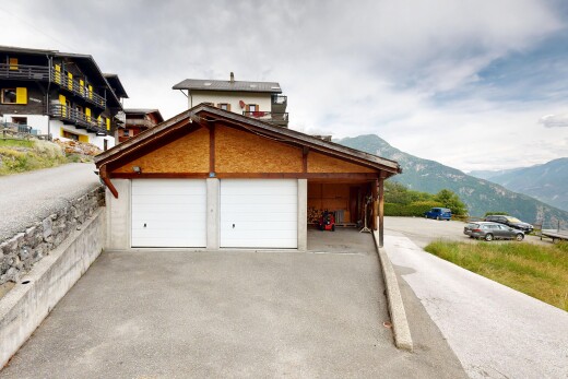 view of home featuring driveway, a mountain view, and a garage