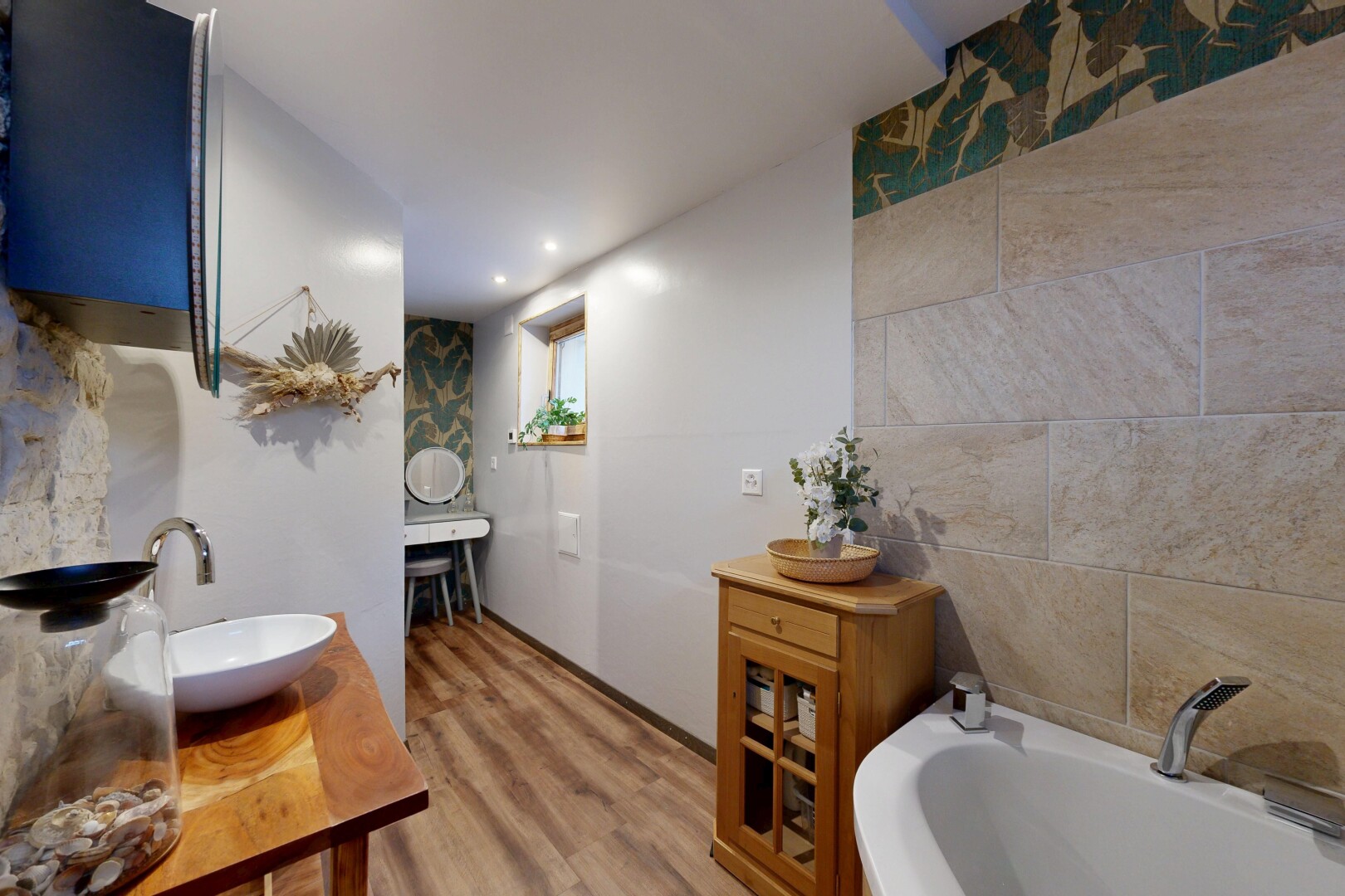 full bath with a garden tub, light wood-style flooring, vanity, and tile walls