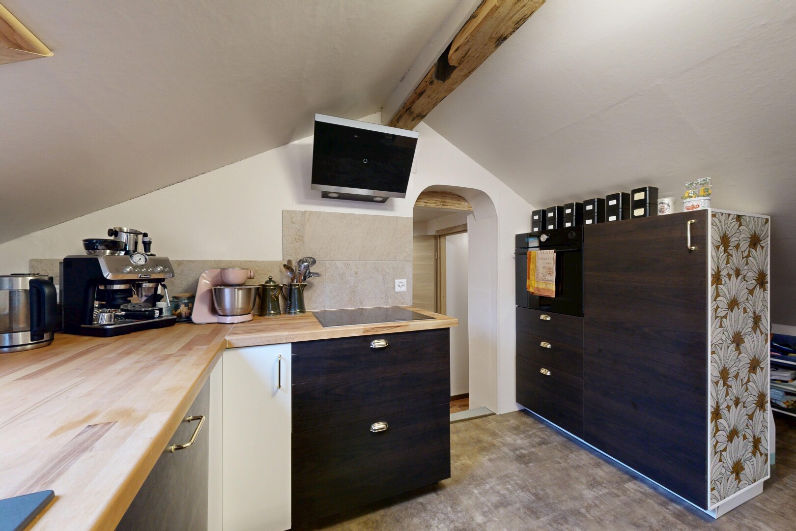 kitchen with arched walkways, black appliances, and butcher block counters