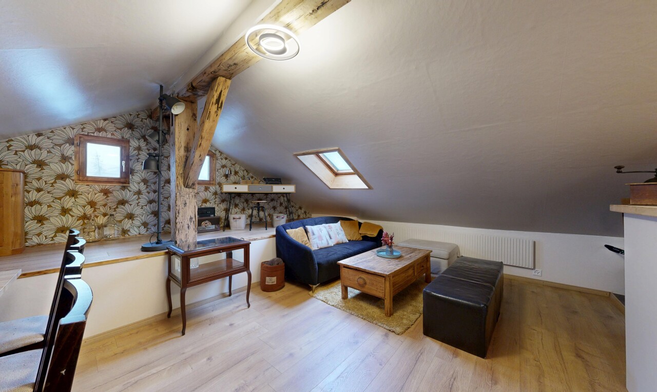 living room featuring a skylight, lofted ceiling, wood finished floors, and wallpapered walls
