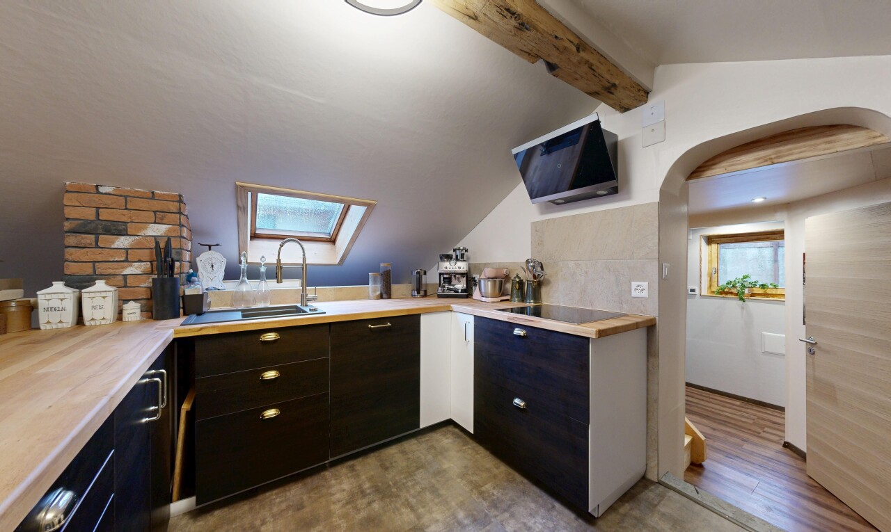 kitchen with a skylight, light countertops, arched walkways, dark wood-style flooring, and black electric cooktop