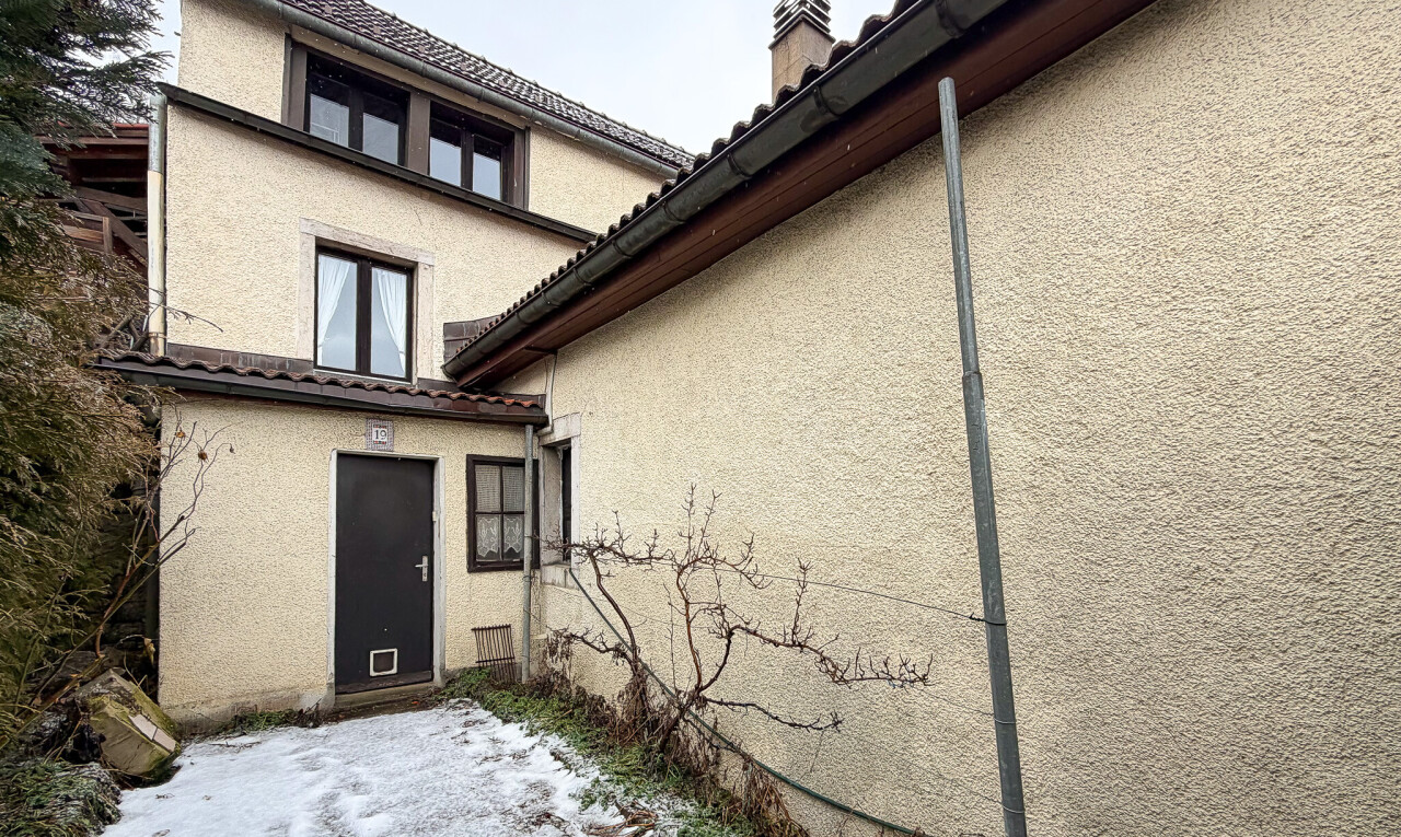 view of home with stucco siding and a chimney