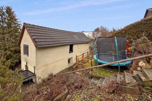 outdoor house featuring a tile roof, a trampoline, and stucco siding