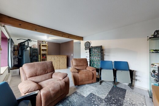 salon avec inside property, cloison sèche, drywall, plafond à poutres, et beamed ceiling