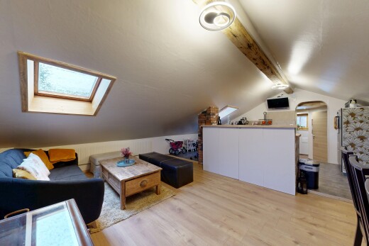 salon avec plafond voûté, vaulted ceiling, sol en finition bois, wood finish floor, et inside property