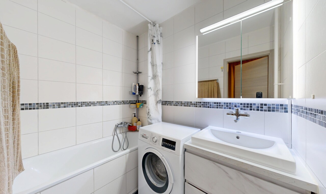 salle de bains avec lave-linge et sèche-linge, mur en carrelage, tile wall, salle de bain complète, et miroir