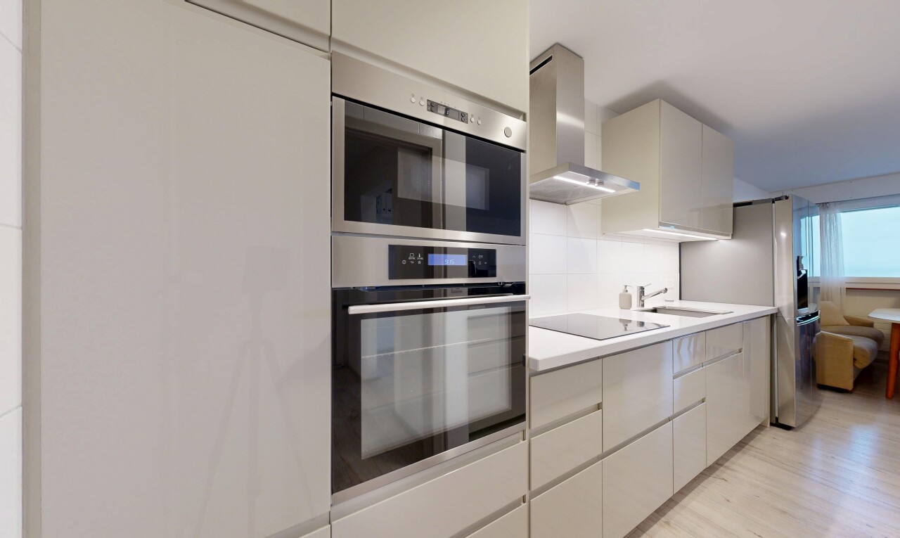 cuisine avec hotte, four double, light floor, light countertops, et plans de travail