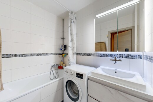 salle de bains avec lave-linge et sèche-linge, mur en carrelage, tile wall, salle de bain complète, et miroir