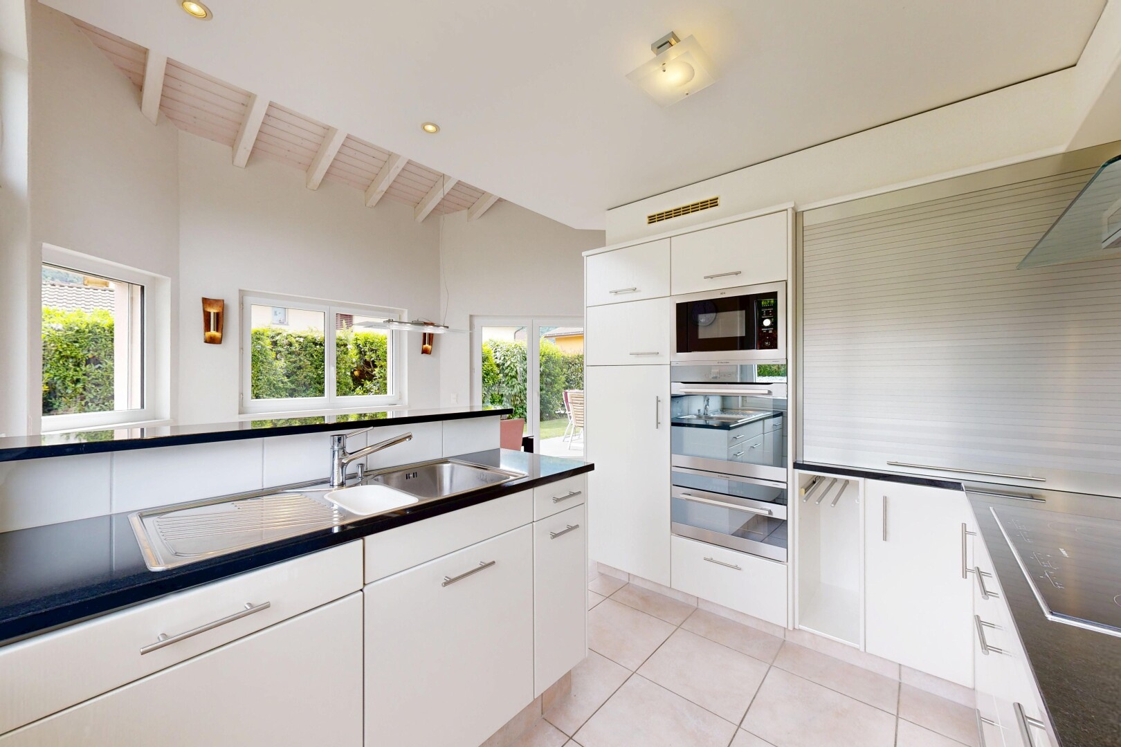 cuisine avec plans de travail, dark countertops, two heights countertops, armoires blanches, et white cabinets