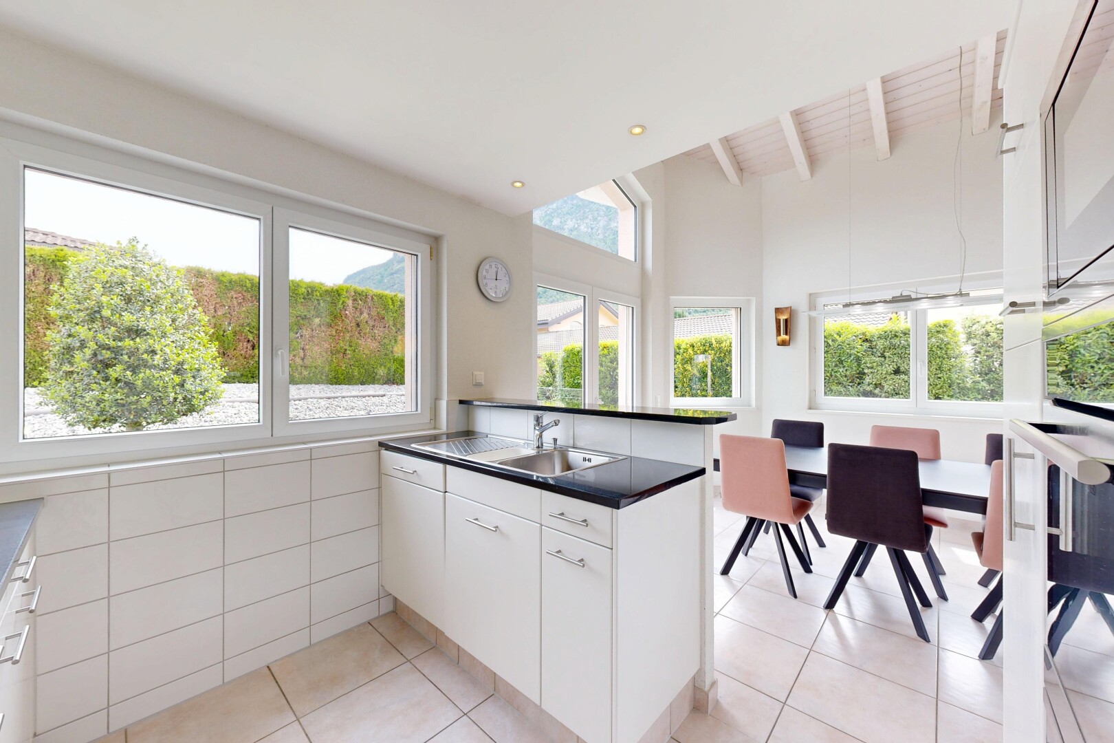 cuisine avec two heights countertops, light floor, armoires blanches, white cabinets, et sol en carrelage