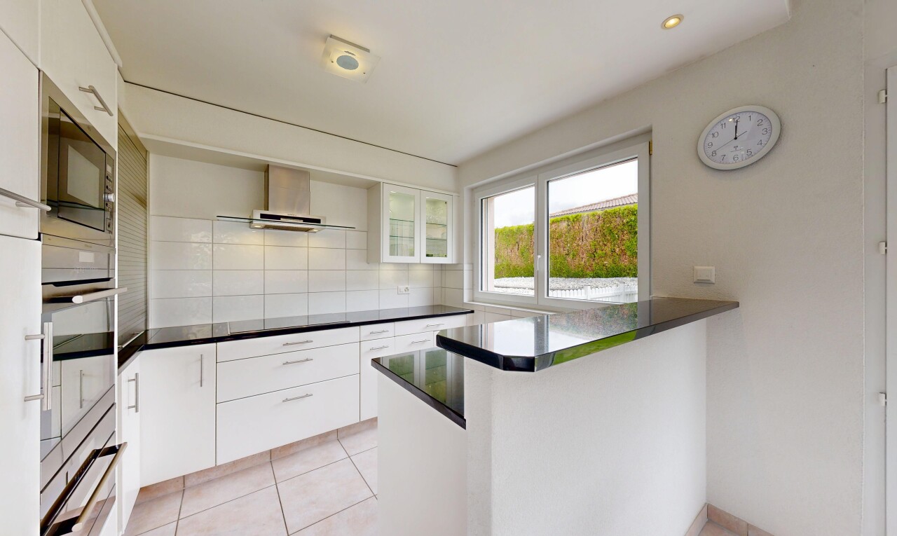 cuisine avec two heights countertops, armoires blanches, white cabinets, dark countertops, et four