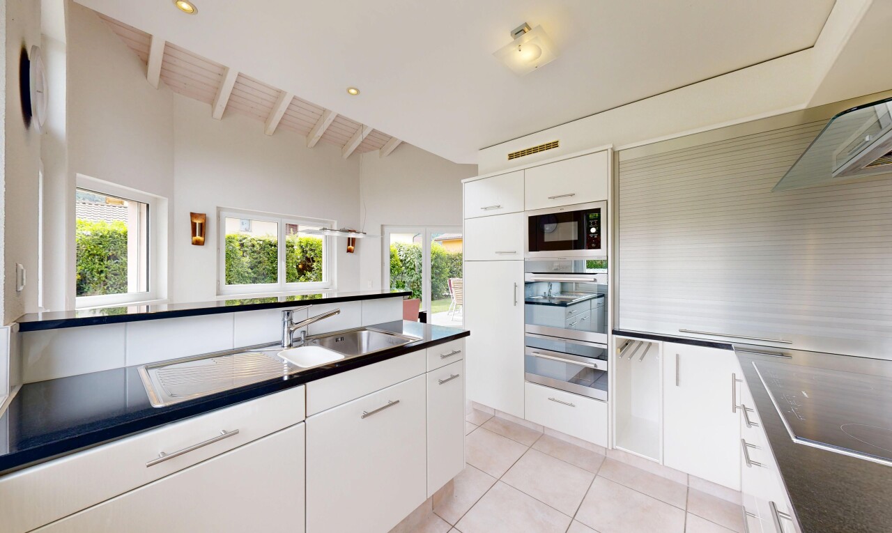 cuisine avec plans de travail, dark countertops, two heights countertops, armoires blanches, et white cabinets