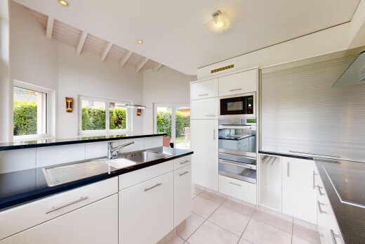 cuisine avec plans de travail, dark countertops, two heights countertops, armoires blanches, et white cabinets