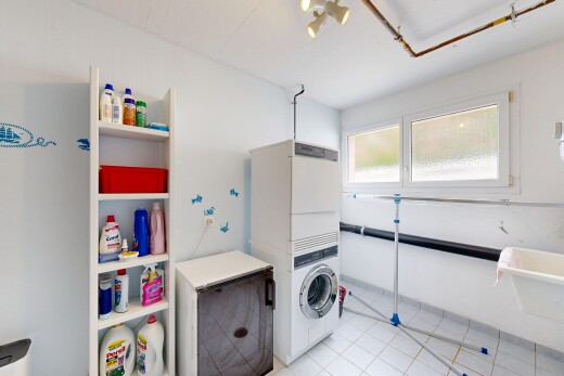 buanderie avec inside property, drywall, cloison sèche, lave-linge et sèche-linge superposés, et light floor