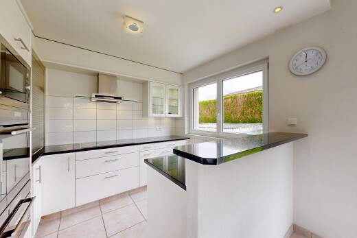 cuisine avec two heights countertops, armoires blanches, white cabinets, dark countertops, et four