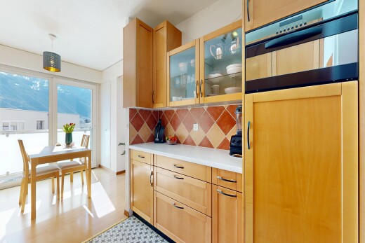 cuisine avec armoires avec insert en verre, glass insert cabinets, armoires marron clair, light brown cabinets, et plans de travail