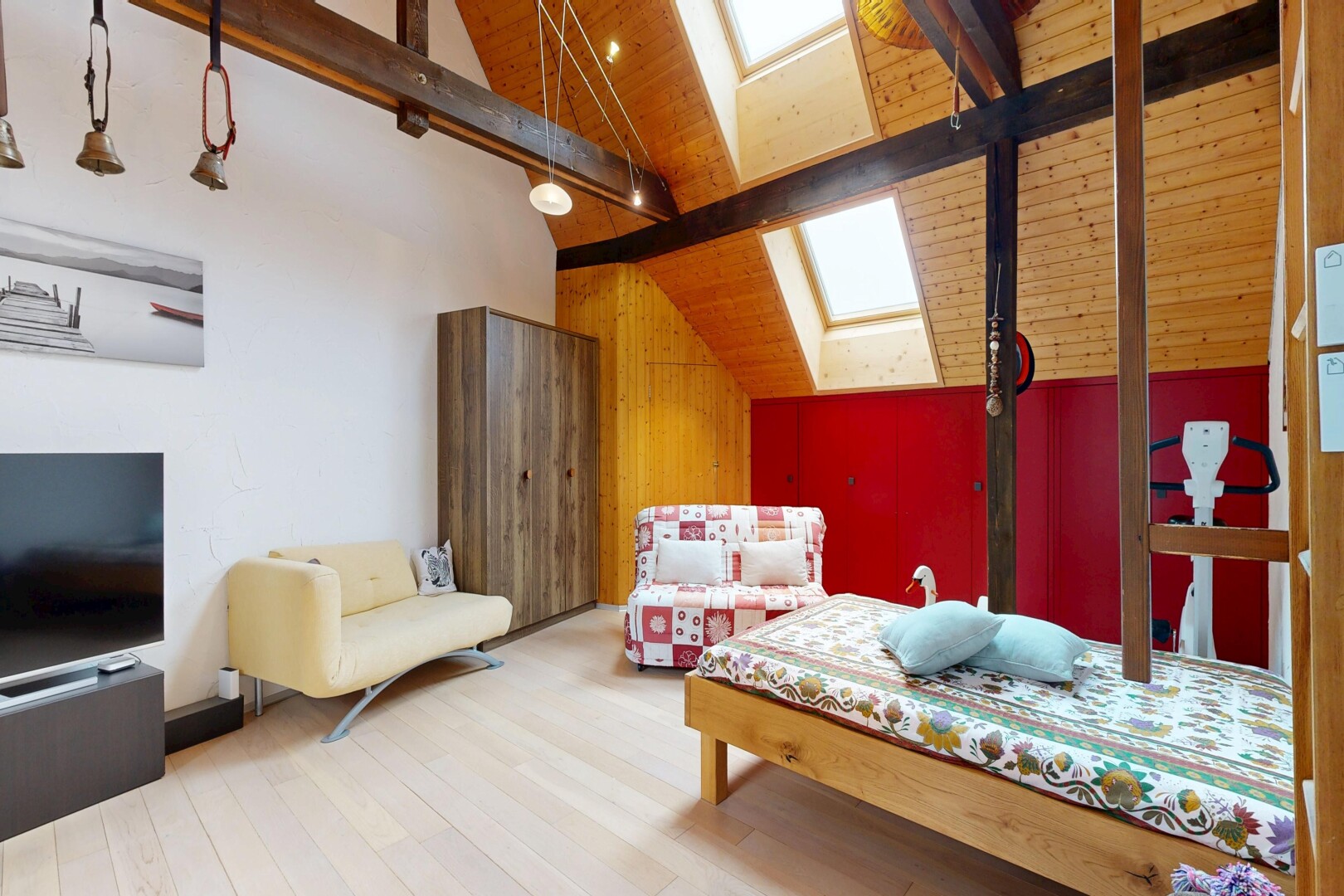 chambre avec puits de lumière, beamed ceiling, plafond à poutres, télévision, et wood finish floor