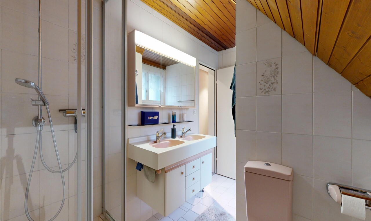 salle de bains avec tile wall, mur en carrelage, miroir, double vasque, et salle de bain complète