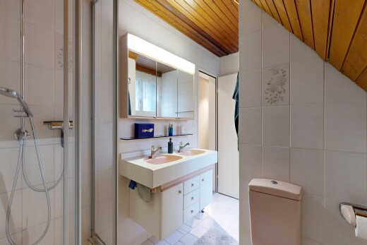 salle de bains avec tile wall, mur en carrelage, miroir, double vasque, et salle de bain complète