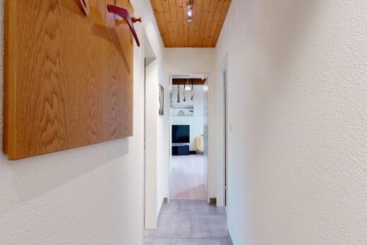 couloir avec plafond en bois, wood ceiling, mur texturé, textured wall, et light floor
