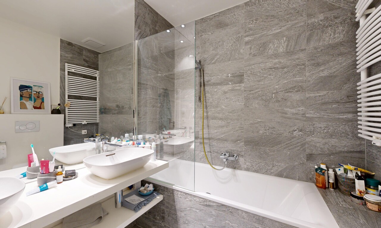 salle de bains avec chauffe-serviettes, radiateur, douche-bain combinés, salle de bain complète, et évier
